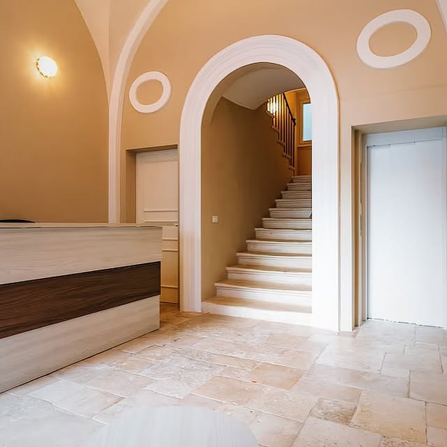 Ingresso elegante con volta ad arco e scale in marmo